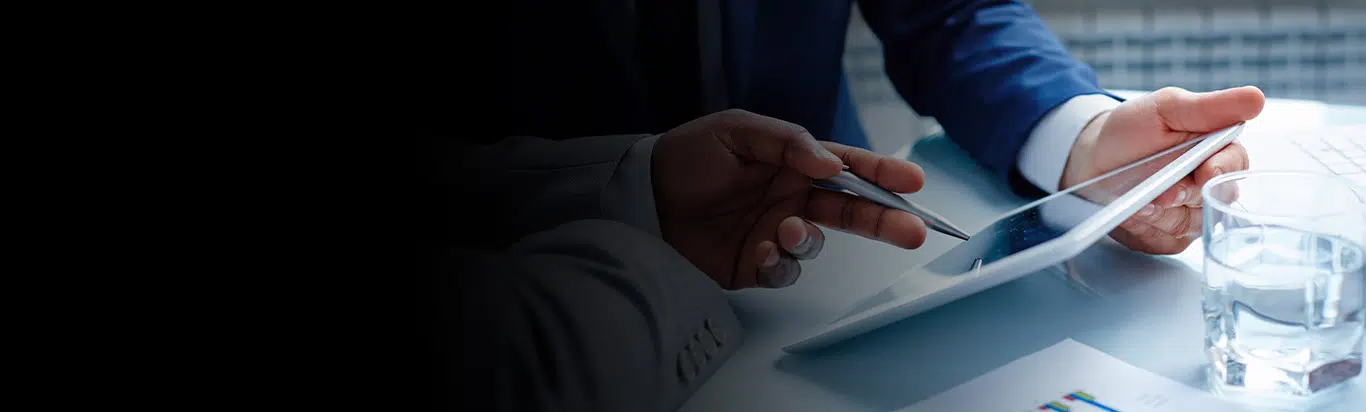 Two pairs of hands pointing at a complaint log on a digital complaint tracking system on a tablet