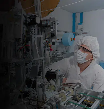 Man investigating a potential nonconformance next to machinery wearing personal protective equipment