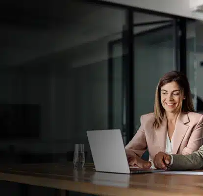 Two business professionals sharing a laptop to view a quality management system review
